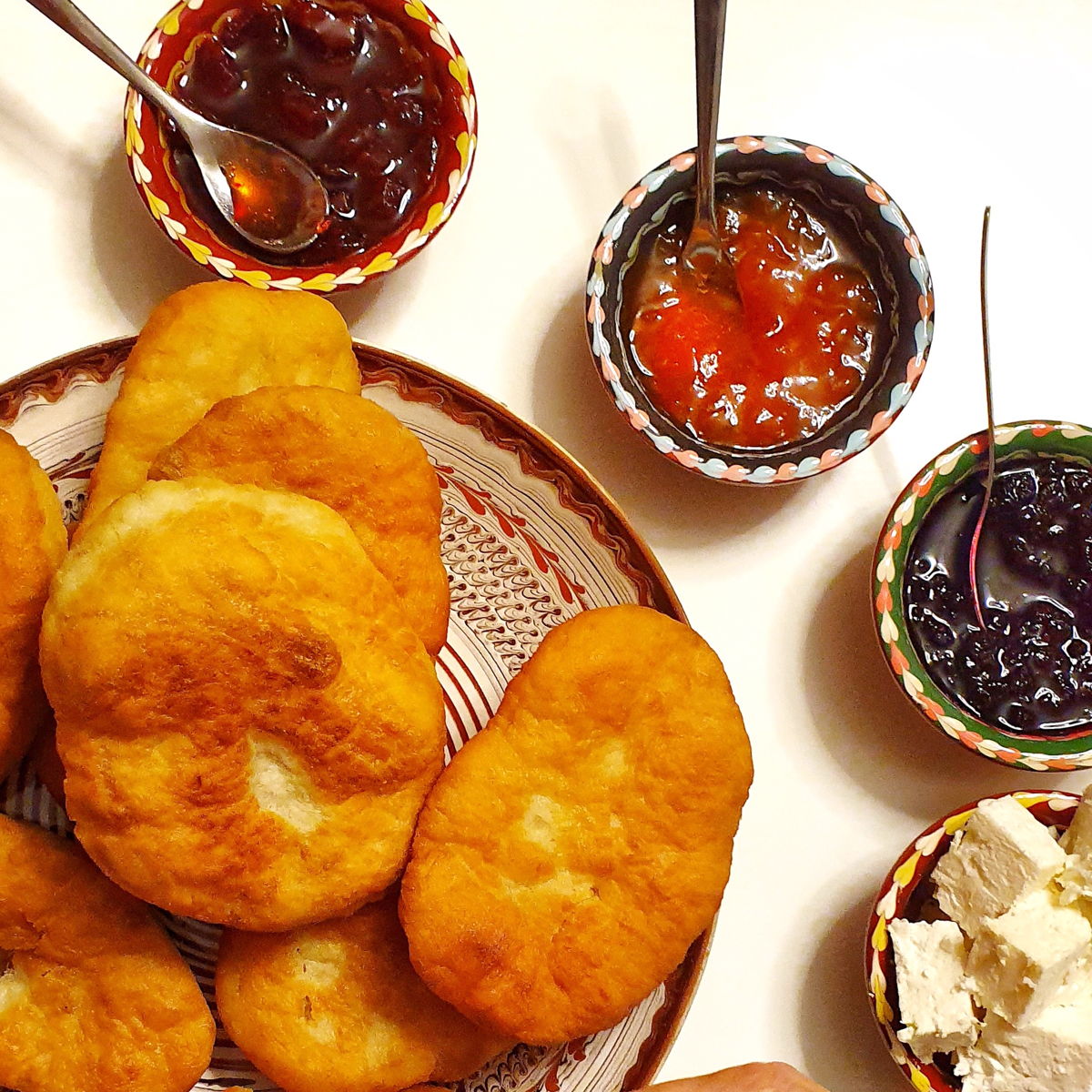 Traditional Romanian fried dough served with local cheeses and homemade jams.